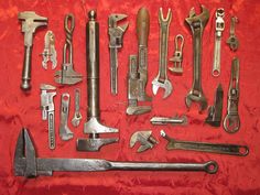 an assortment of tools are displayed on a red cloth