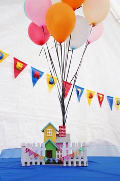 there is a small house with balloons in the air