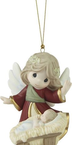 a christmas ornament with an angel holding a baby in it's crib