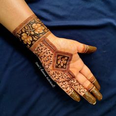 a woman's hand with henna tattoos on it