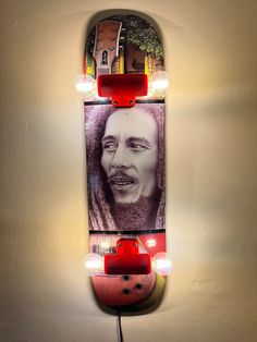 a skateboard mounted to the side of a wall next to a red light bulb