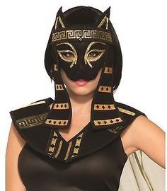 a woman wearing an egyptian mask and black dress