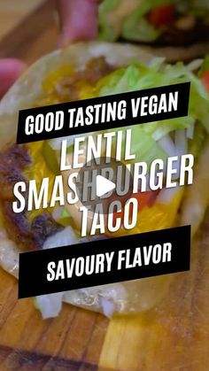 a taco sitting on top of a wooden cutting board with the words good tasting vegan lentil smashburger taco