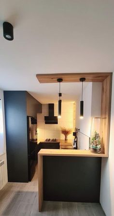 a kitchen with black cabinets and wooden counter tops, along with an island in the middle