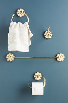 a towel rack with two rolls of toilet paper on it next to a gold towel bar