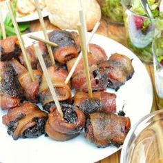 several skewered meats are on a white plate with toothpicks sticking out of them