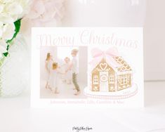 a christmas card with a gingerbread house and pink ribbon on the front is shown