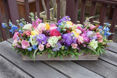 a wooden box filled with lots of colorful flowers