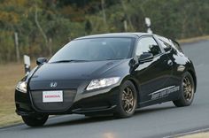 a black sports car driving down the road