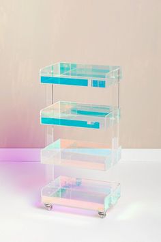 three tiered clear acrylic display case with blue and pink dividers on wheels