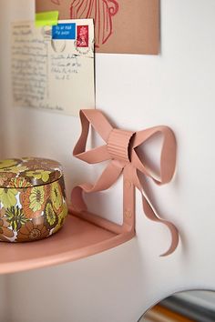 a pink shelf with a bow on it