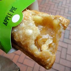 a piece of food that is on top of a person's hand with a green ribbon around it