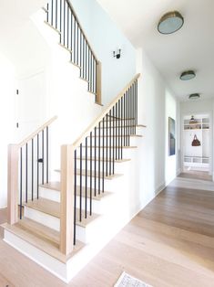 a white staircase with wooden handrails in a house