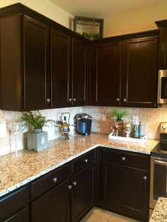 a kitchen with dark wood cabinets and granite counter tops is seen in this image from the front view