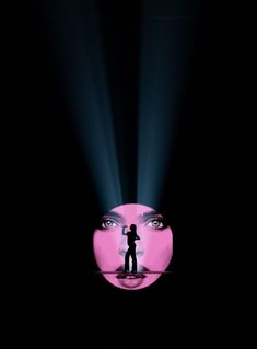 a person standing in front of a pink light