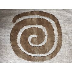 a brown and white rug with a spiral design on it