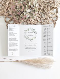 the wedding program is laid out on top of a white table cloth with flowers in it