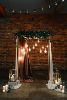 an image of a wedding arch decorated with lights and greenery on the wall behind it