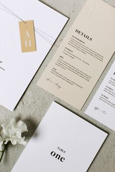 the wedding stationery is laid out on top of each other, with a single flower