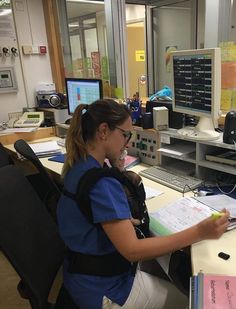 a woman sitting at a desk in front of a computer monitor and calculator