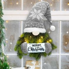 a christmas wreath with a santa hat on it and a sign that says merry christmas