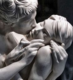 there is a statue of two people kissing each other with their hands on the face