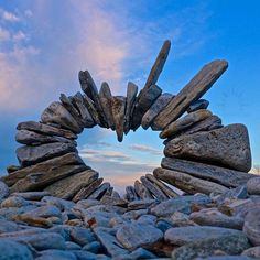 rocks arranged in the shape of a heart against a blue sky with wispy clouds