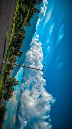 the sky and clouds are reflected in the water on the road side, as seen from an airplane window