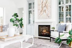 a living room filled with furniture and a fire place in the middle of a room