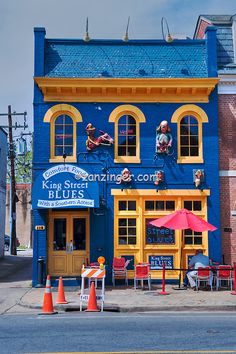 a blue building with yellow trim and windows