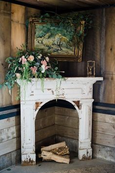 an old fireplace with flowers and greenery on top