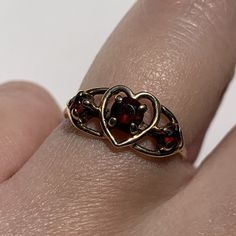 A charming vintage ring with three garnets and a heart detail to the center. Crafted in solid 9ct gold. Hallmarked. In excellent vintage condition. Professionally cleaned & polished.  Comes in a presentation box and will be sent Royal Mail Special Delivery. Refer to images for more information. Size: UK size I 1/2, US size 4 1/2. Weight: 1.4 grams. Vintage Heart Ring With Birthstone For Valentine's Day, Vintage Birthstone Rings For Valentine's Day, Vintage Gold Garnet Birthstone Ring, Vintage Garnet Birthstone Promise Ring, Vintage Heart Ring With Birthstone, Vintage Heart Cut Birthstone Ring, Vintage Heart Cut Birthstone Heart Ring, Vintage Garnet Birthstone Ring For Anniversary, Vintage Garnet Ring