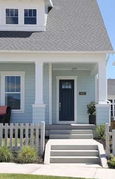 a blue house with steps leading up to the front door