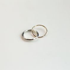 Two inseparable interlocking bands, one slender and the other almost twice the weight. The ring is available in two versions, one with a gold and sterling silver band, and the other with both bands in gold. A distinct and timeless piece from our most recent series of rings signifying closeness. This ring looks beautiful on its own, but it can be layered with other silver and gold pieces as well. Thinner band: 1.3mm, recycled 9k yellow gold / recycled 18k yellow gold Heavier band: 2.5mm, sterling Double Band Stackable Promise Rings, Stackable White Gold Bands Open Ring, Stackable White Gold Open Ring Bands, Stackable White Gold Bands, Stackable Sterling Silver Dome Ring For Promise, Stackable Sterling Silver Dome Promise Ring, Timeless Double Band Stackable Promise Rings, Silver Stackable Dome Ring For Promise, Gold Sterling Silver Double Band Stackable Rings