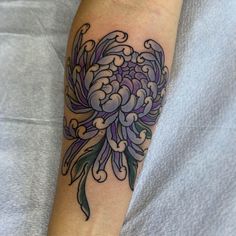 a person with a tattoo on their arm has a flower in the shape of a heart