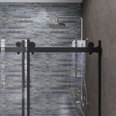 a glass shower door in the corner of a bathroom with tile walls and flooring