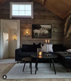 a living room filled with furniture and wooden walls