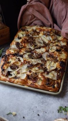 an uncooked pizza sitting on top of a pan next to other food items