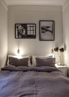 a bed with two pictures on the wall above it