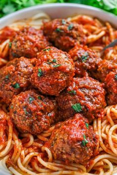 spaghetti and meatballs in a white bowl with parsley on the side, ready to be eaten