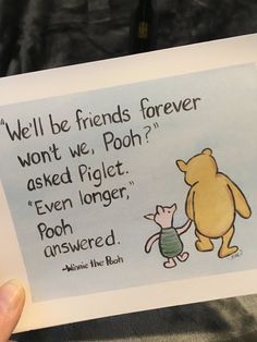 someone holding up a card with winnie the pooh and piggie on it