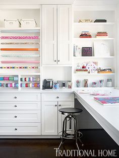 a kitchen with white cabinets and lots of crafting supplies