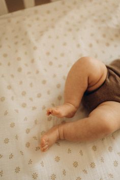 a baby laying on top of a bed in a crib