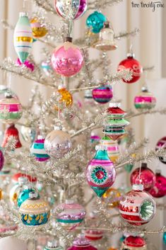 a white christmas tree with ornaments hanging from it