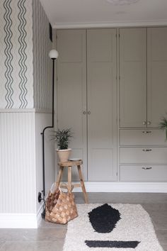 a room with white cabinets and a rug on the floor