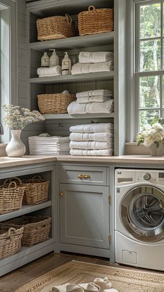 a washer and dryer in a room with lots of linens on the shelves