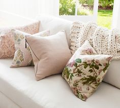 a white couch with many pillows on it