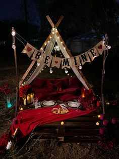 a bed that has been set up with candles and lights on it in the dark