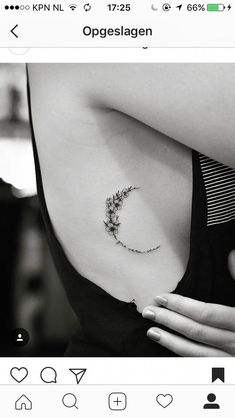 a black and white photo of a woman's stomach with a flower tattoo on it