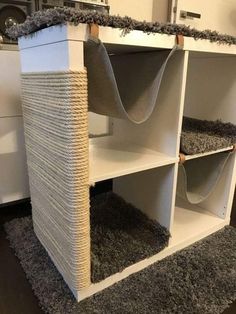 a cat scratching tower in the corner of a living room with carpet on the floor